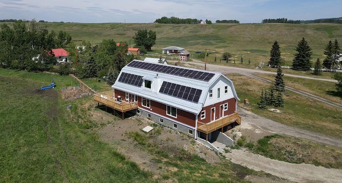 Aerial view of a two-story house with a solar panel array on the roof.
