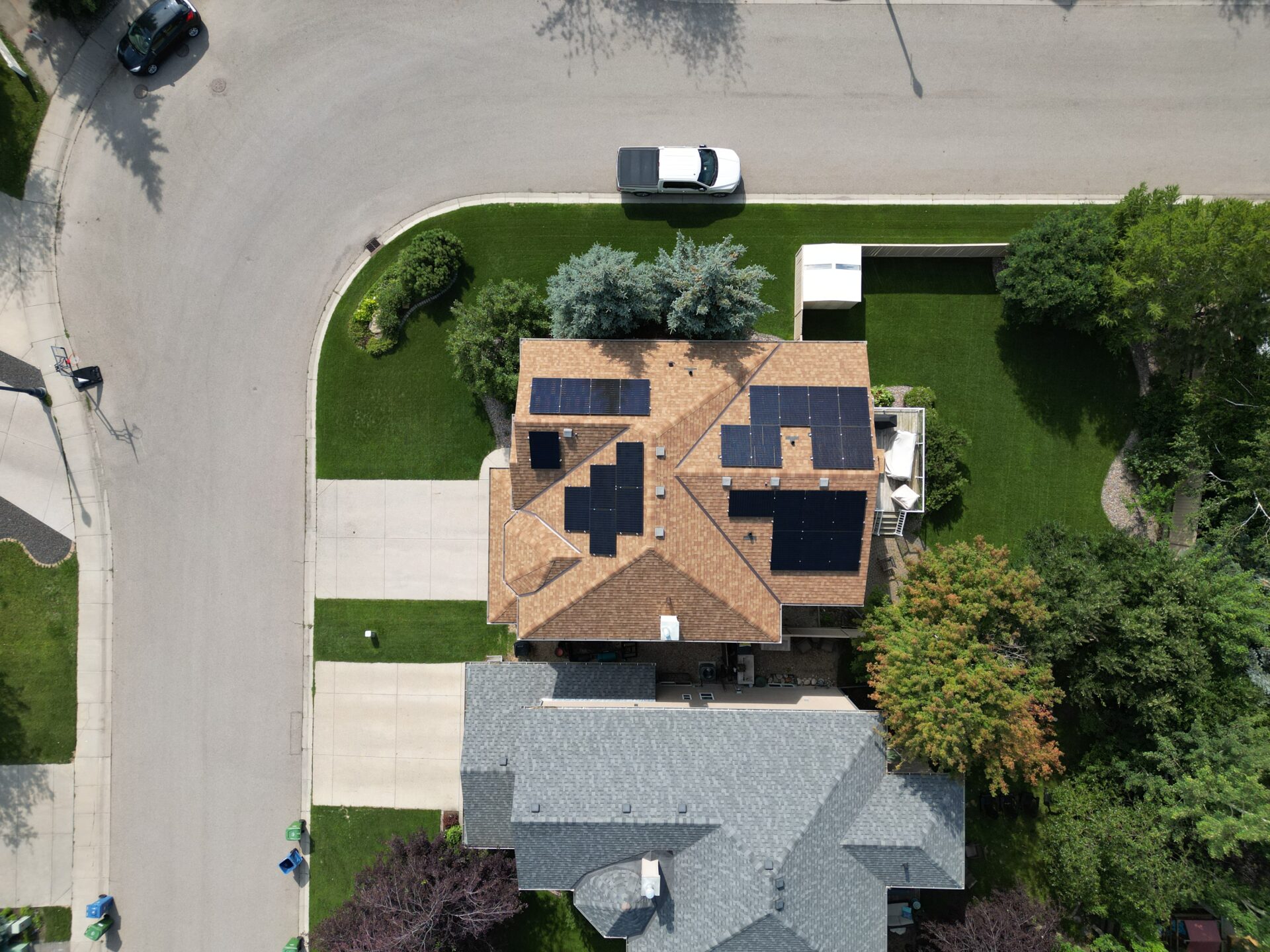 Aerial drone view of a high-efficiency residential solar panel installation in Strathcona Park, SW Calgary, by Rocky Mountain Solar Co.