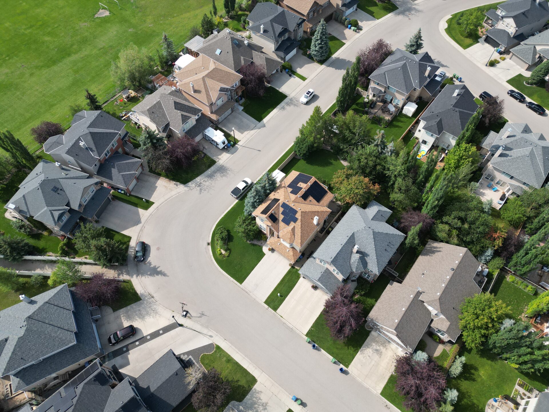 Aerial perspective of a 13 kW residential solar power system on a modern home in Strathcona Park, Calgary.