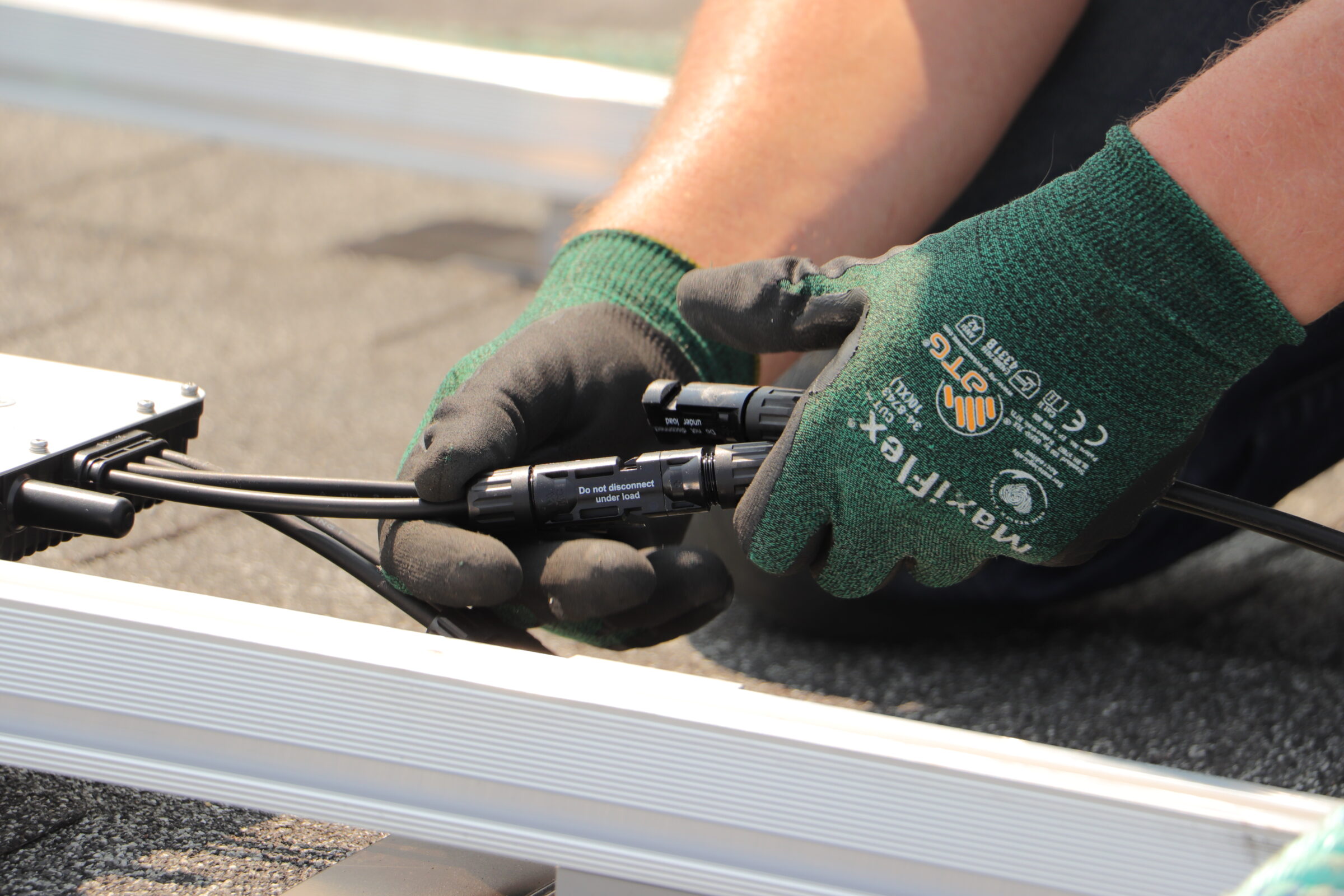 Close-up of solar panel DC wiring and MC4 connectors being secured by a professional Calgary solar installer.