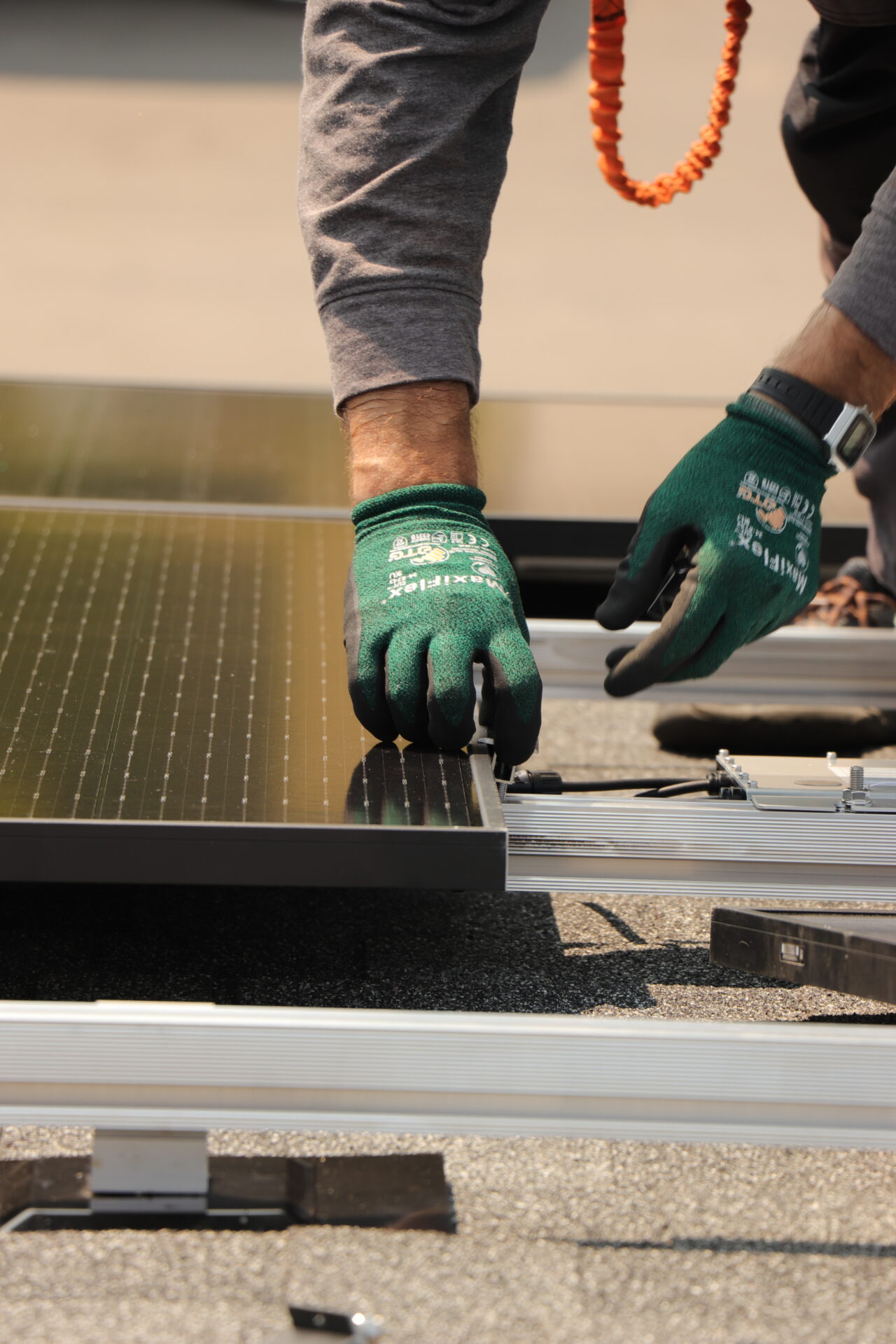 Close-up of a Calgary solar installer securing mounting hardware for a residential rooftop solar array.