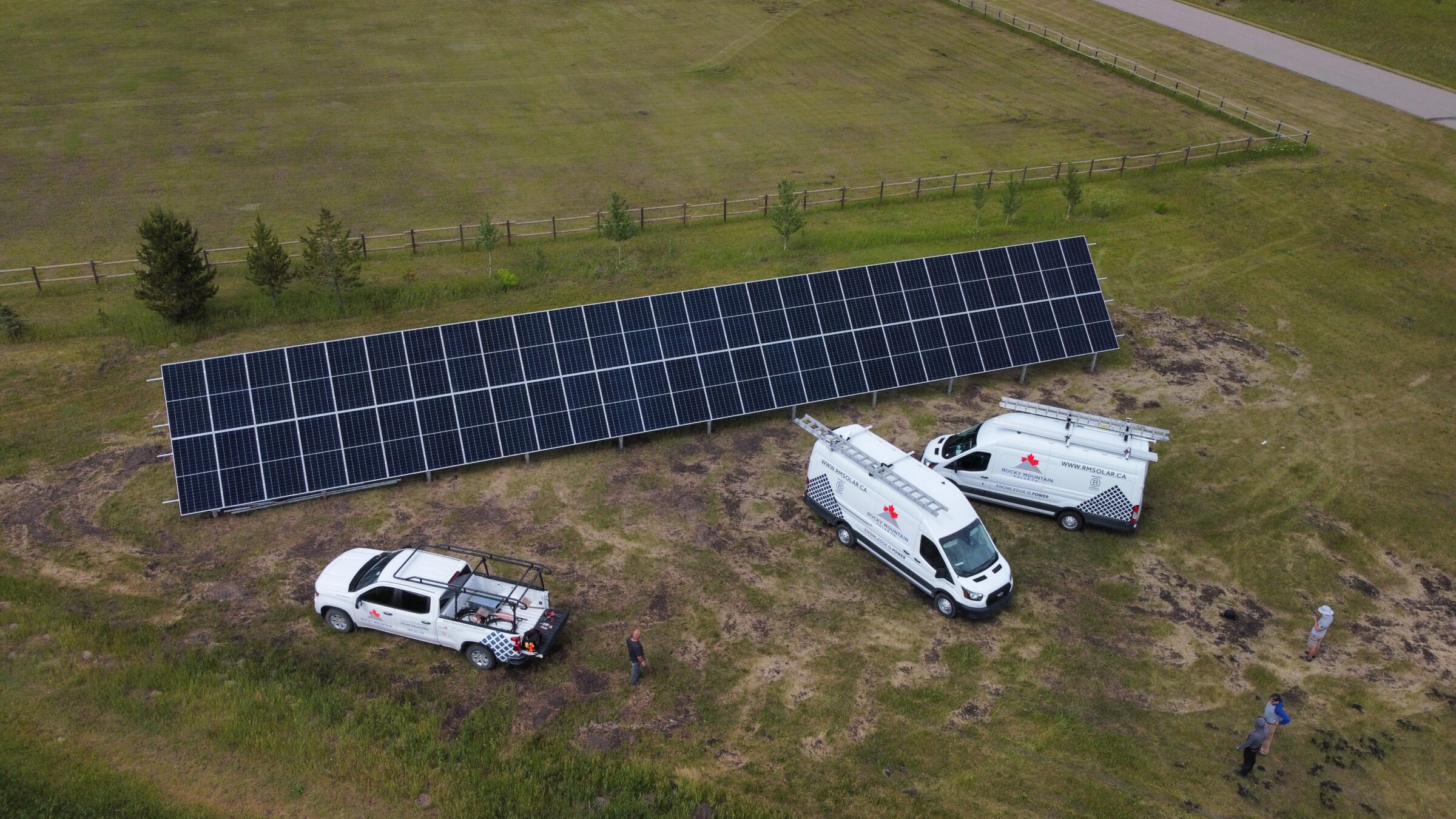 A large residential ground-mount solar panel array installed in an open field by Rocky Mountain Solar Co.