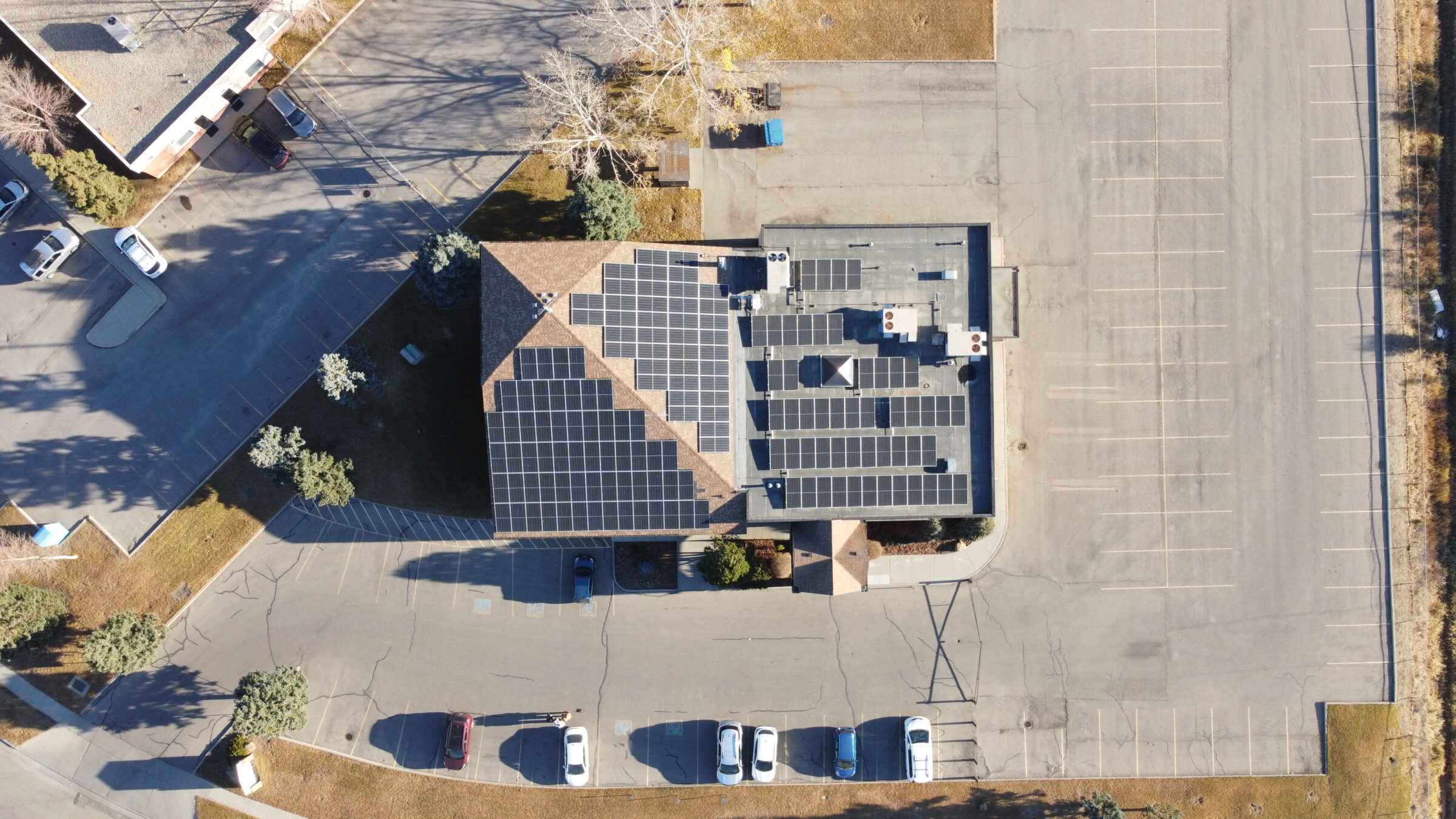 Close-up of a Calgary solar installer's hands in safety gloves securing a solar panel to a rooftop racking system.