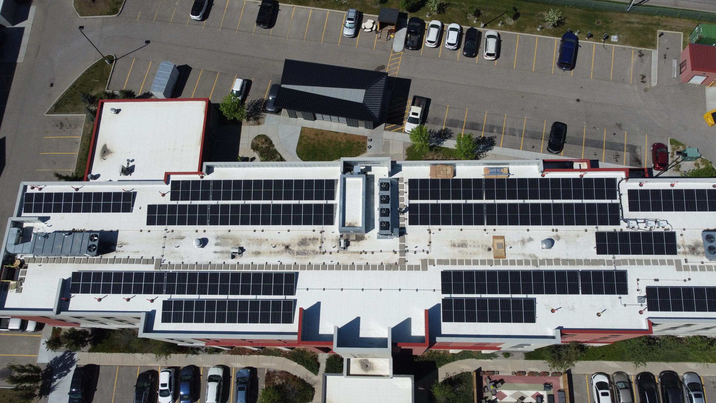 Aerial drone view of a massive commercial flat-roof solar panel array using Soprasolar integrated racking.