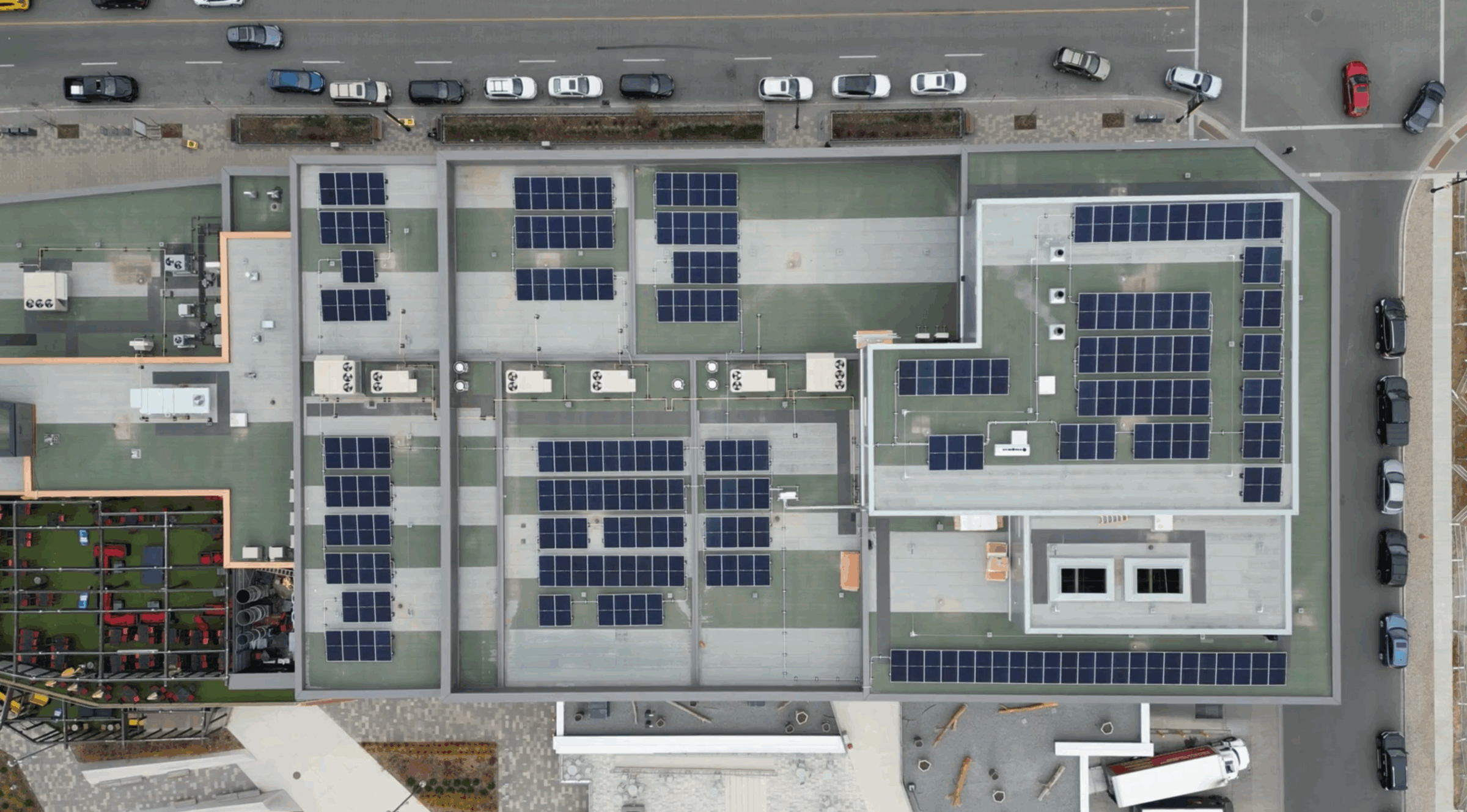 Aerial drone view of a large-scale commercial solar panel installation on a flat roof in Calgary’s University District.