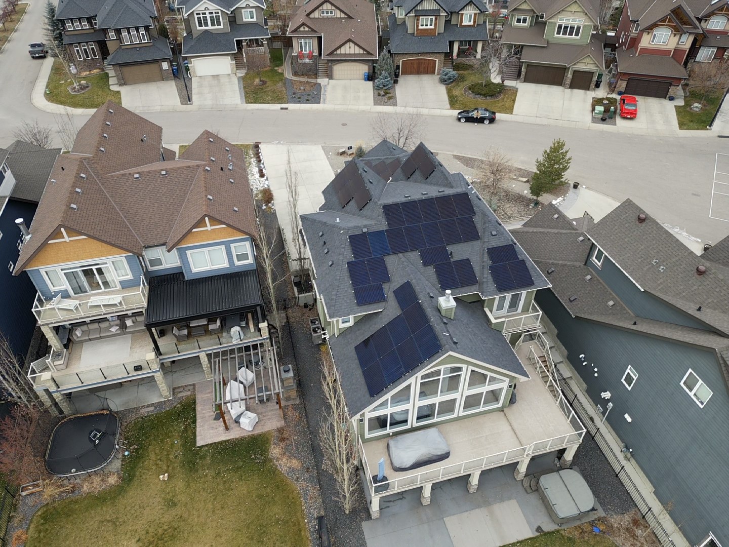Professional Calgary solar installer inspecting a newly installed residential solar panel array.