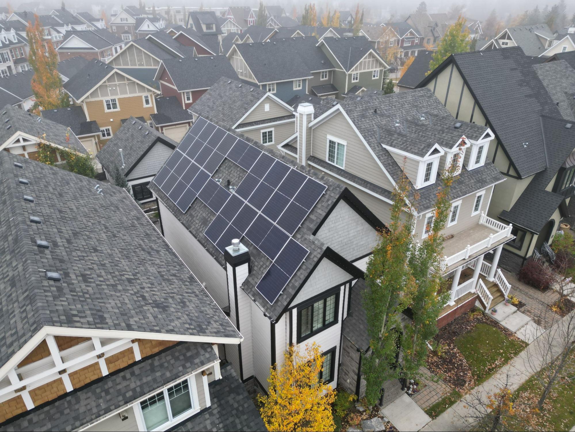 Residential home with rooftop solar panels, highlighting the benefits of solar energy for property owners.