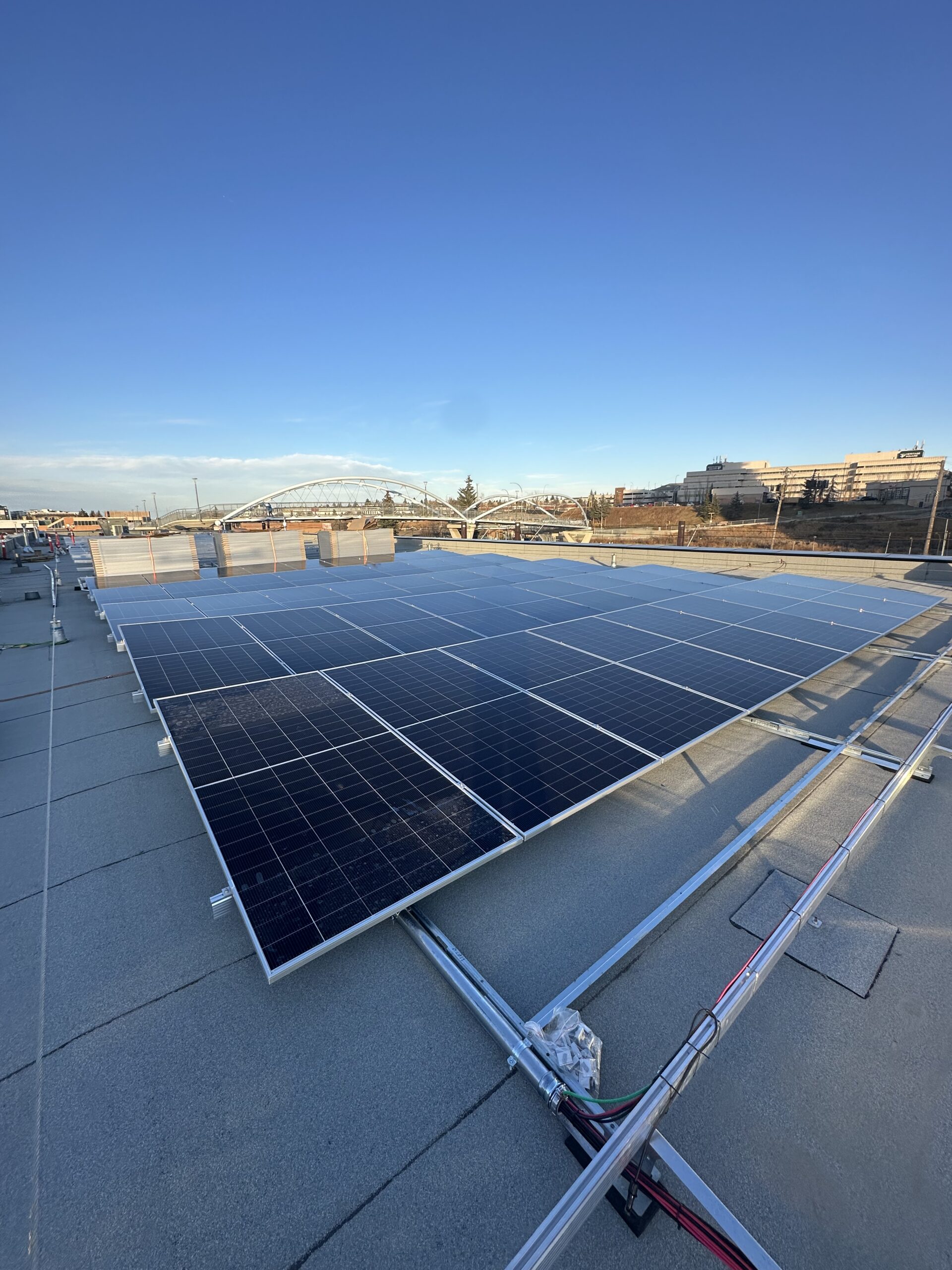 Close-up of integrated commercial solar racking on an IKO Diamond Shield roof at the Haysboro LRT station in Calgary.