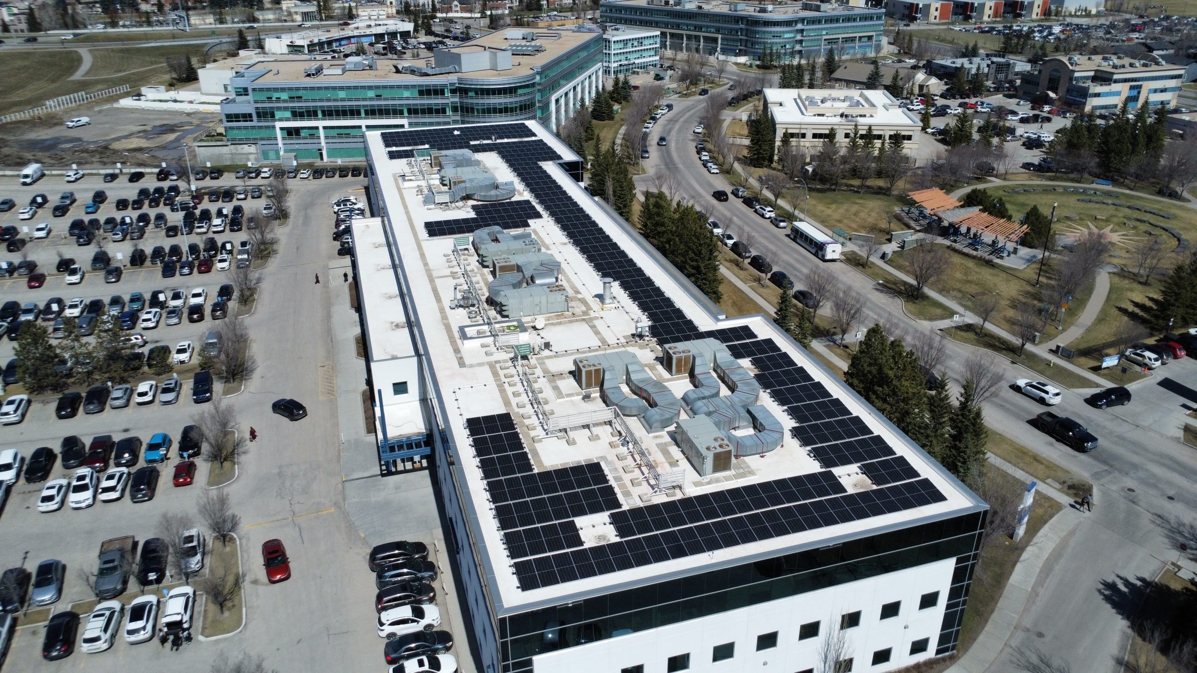 Aerial view of a ballast-free Soprasolar PVC pedestal solar panel installation on a commercial flat roof in Western Canada by Rocky Mountain Solar Co.
